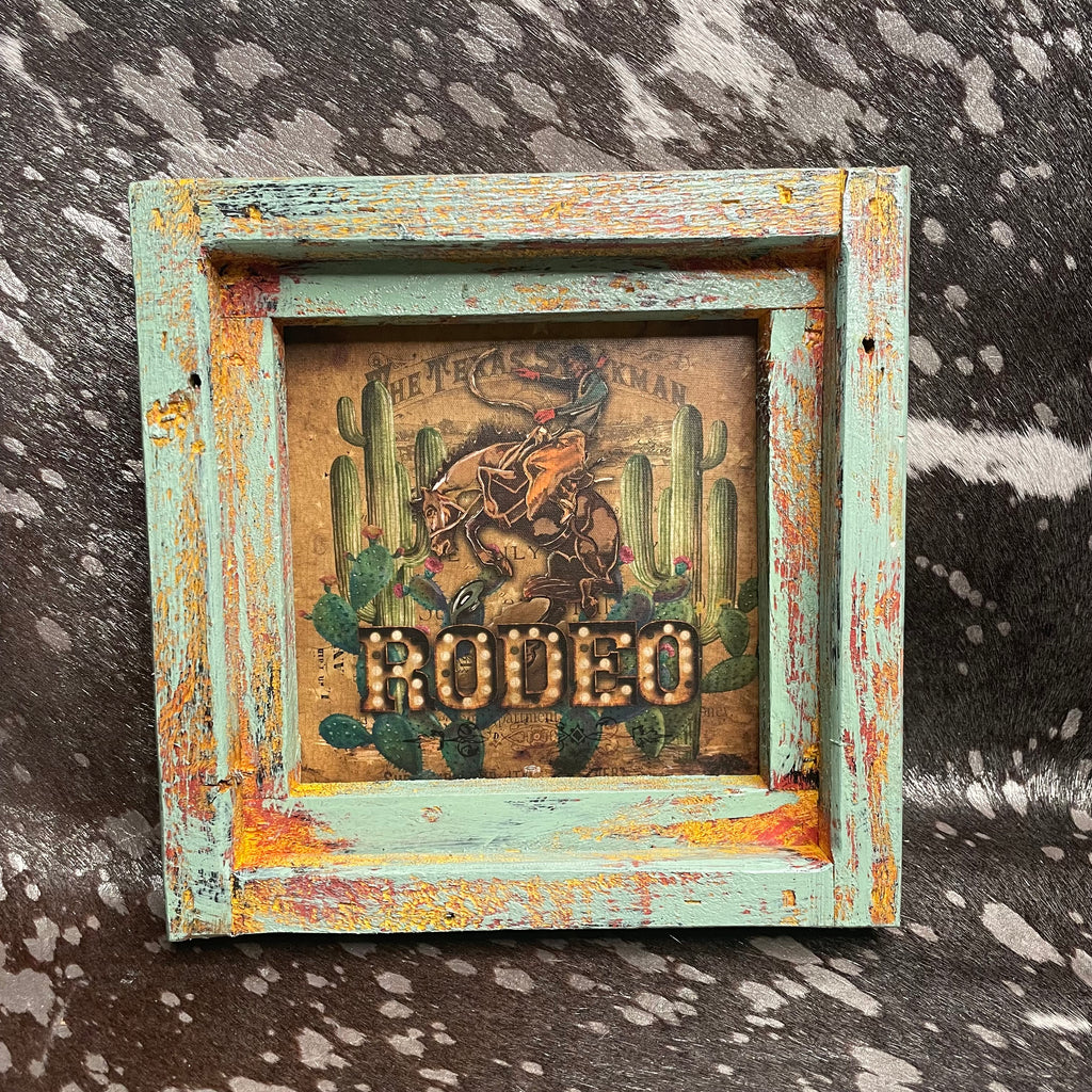 Decorative framed picture with a cowboy and cactus design on a textured background