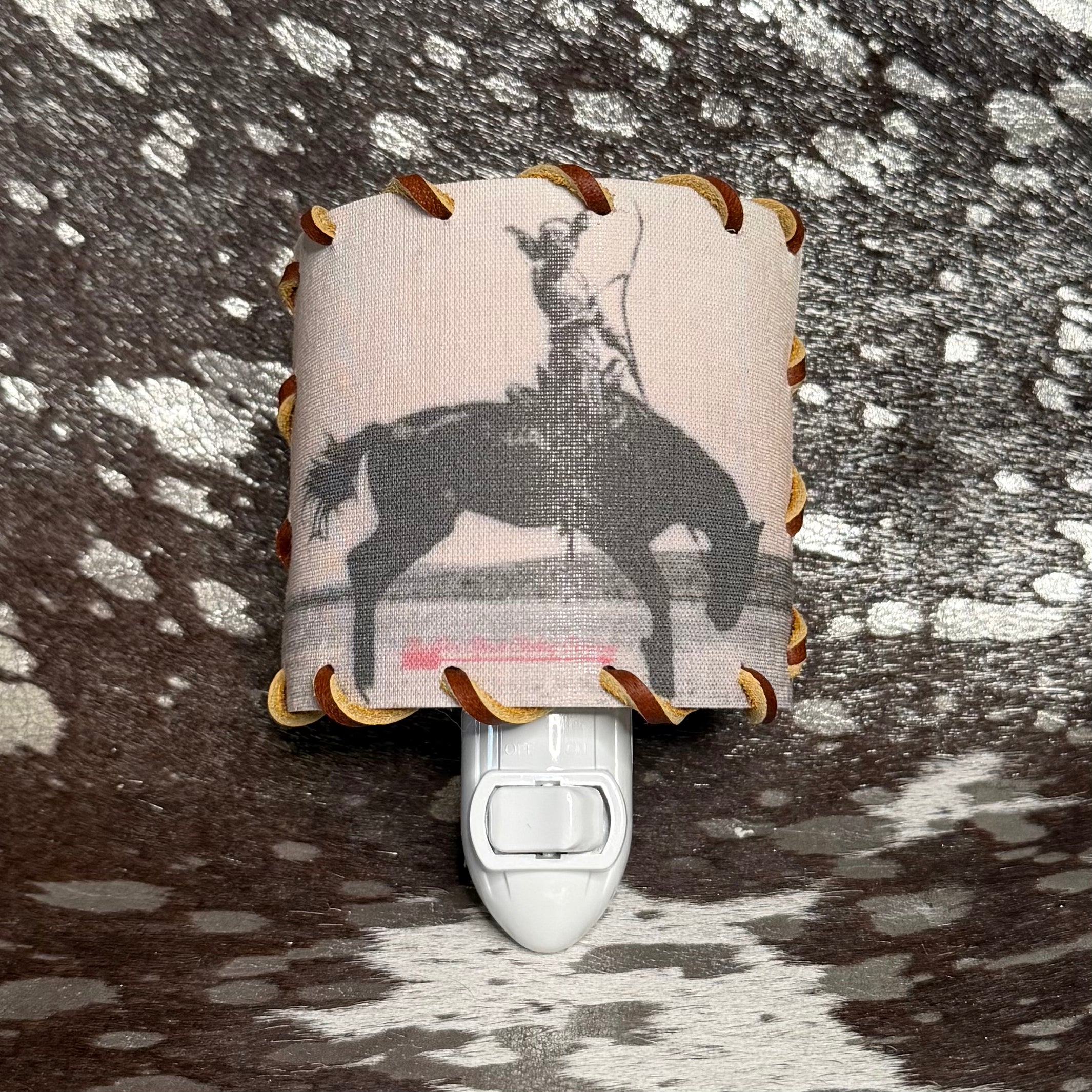 Decorative night light with horse and rider design on a textured surface